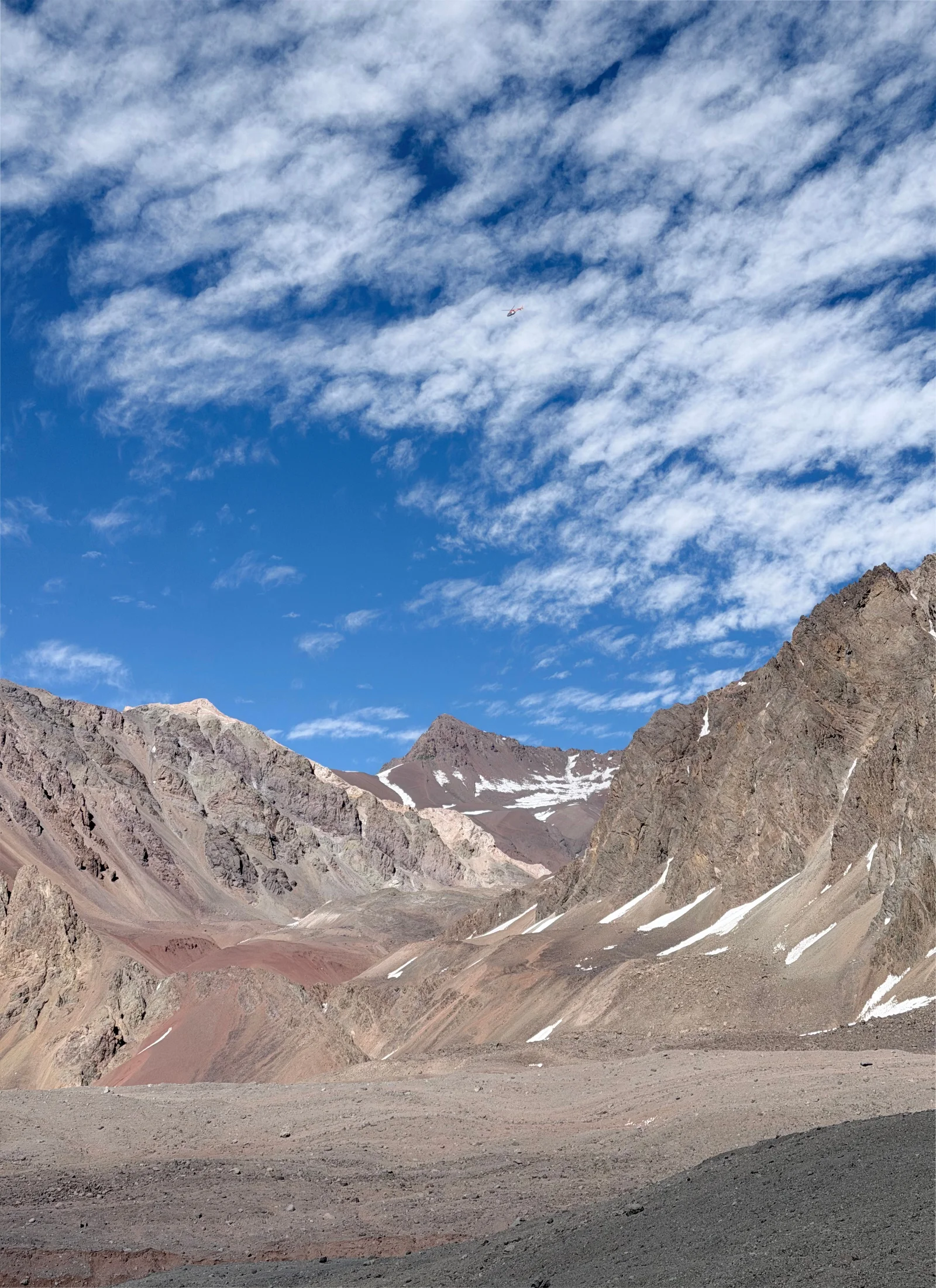 Climbers ascending toward the summit at dawn with the mountain shadow stretching below