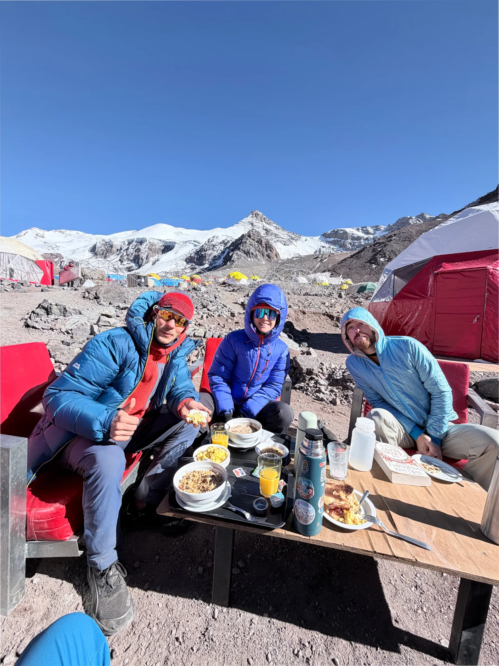 Three expedition members enjoying a meal at high camp
