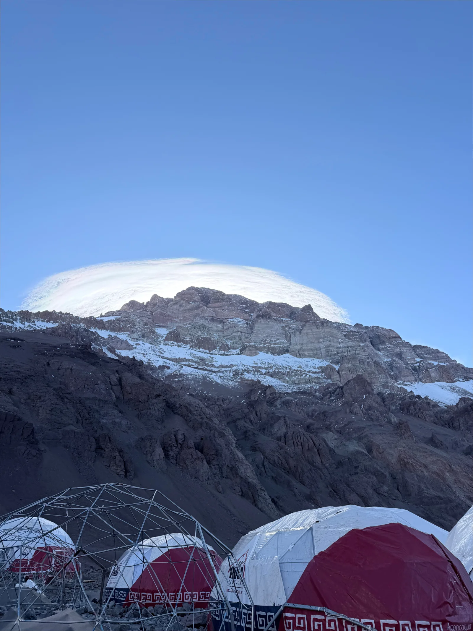 Base camp geodesic domes with a lenticular cloud capping the summit